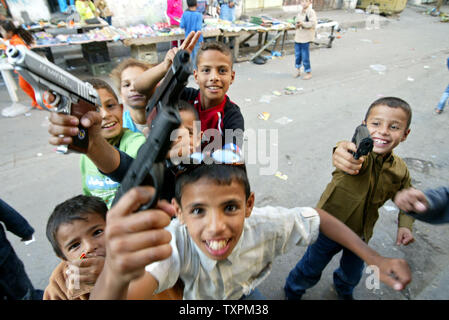 Bambini palestinesi giocare con pistole giocattolo per celebrare l'Eid al-Fitr il 3 novembre 2005 nella città di Gaza. Eid al-Fitr è la fine del il mese del Ramadan. (UPI foto /Ismael Mohamad) Foto Stock