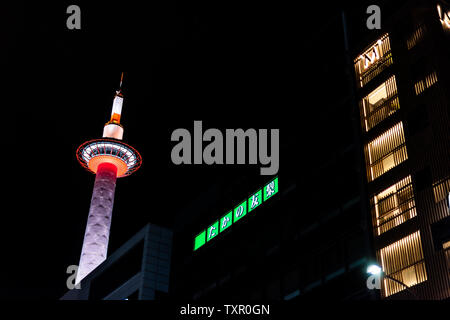 Kyoto, Giappone - 13 Aprile 2019: Skyline cityscape durante il giorno della grande città con torre vicino la stazione durante il buio della notte nera e edifici illuminati Foto Stock