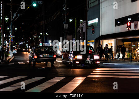 Kyoto, Giappone - 13 Aprile 2019: strada del centro con edifici segni e black taxi nel traffico Foto Stock