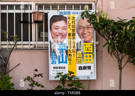 Kyoto, Giappone - 14 Aprile 2019: campagna elettorale segno sulla strada dalla Casa della parete edilizia poster in Giapponese e due candidati Foto Stock