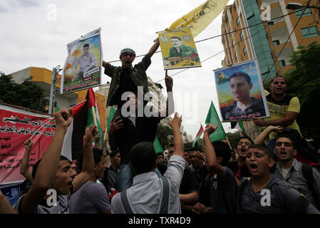 Palestinesi chant slogan che prendono parte ad una manifestazione che celebra un prigioniero di swap tra Hamas e Israele nella Striscia di Gaza City il 12 ottobre 2011. Gli israeliani ha accolto con favore il mercoledì un importante prigioniero swap che libererà soldier Gilad Shalit dopo cinque anni in cattività in cambio della liberazione di mille palestinesi. UPI/Ismael Mohamad Foto Stock