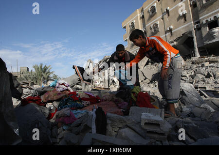 Giovani palestinesi attraverso la ricerca di macerie di edifici distrutti a seguito incursioni aeree israeliane sulla striscia di Gaza meridionale città di Rafah il 18 novembre 2012. Israele hanno bombardato alcuni obiettivi a Gaza per un quinto dritto nella giornata di domenica il ferimento di almeno sei giornalisti, come un raid separati nel nord della Striscia di Gaza ha ucciso due persone, medici palestinesi fonti. UPI/Ismael Mohamad Foto Stock