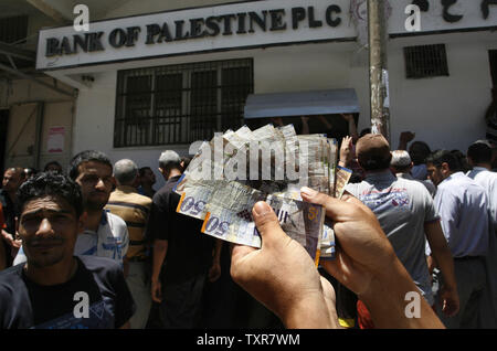 Un funzionario pagato dall'Autorità Palestinese visualizza Nuovo sheqel israeliano (NSI) fatture dopo ha preso il suo stipendio da una banca di Gaza City il 11 giugno 2014. La polizia palestinese nella Striscia di Gaza ha permesso alle banche di aprire dopo essere stato chiuso per sei giorni seguenti tafferugli con i funzionari di Hamas su stipendi non pagati. UPI/Ismael Mohamad Foto Stock