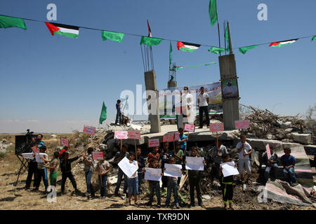 Un palestinese dà un discorso accanto ai bambini azienda cartelloni e manifesti durante un rally segnando il sessantasettesimo anniversario della "La Nakba" il 15 maggio 2015. vicino al confine con Israele, a est di Khan Younis nel sud della striscia di Gaza. 'La Nakba" significa in arabo "catastrofe" in riferimento alla nascita dello Stato di Israele 67 anni fa in British-Palestina mandataria, che ha causato lo sfollamento di centinaia di migliaia di palestinesi che sono fuggiti o sono stati cacciati dalle loro case durante la guerra del 1948 su Israele per la creazione. Foto di Ismael Mohamad/UPI Foto Stock