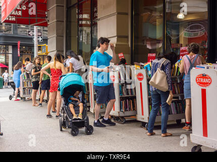 Gli amanti dello shopping ricerca di occasioni e lettura estiva presso il recentemente peculiare Strand Bookstore di New York quartiere del Greenwich Village il Sabato, 22 giugno 2019. (© Richard B. Levine) Foto Stock