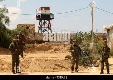 Un confine egiziano appare sullo sfondo come il palestinese Hamas delle forze di sicurezza pattugliano la zona di frontiera di Rafah tra Gaza ed Egitto su Aprel 14, 2016. Hamas chiede l Egitto per allentare il blocco da Gaza come chiamate in Egitto per Hamas di aumentare il numero di truppe e di controllo della frontiera tra Egitto e la striscia di Gaza .Hamas chiamato per l'Egitto per allentare le restrizioni sulla striscia di Gaza, un delegato detto, dopo da funzionari del gruppo islamista recato al Cairo per cercare di ricucire rapporti tesi. Alto funzionario Khalil al-Haya detto Hamas aveva implorato Egitto per consentire più traffico attraverso il confine Rafa cros Foto Stock