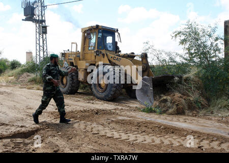 Una sicurezza palestinese uomo dirige un bulldozer al lavoro sulla zona di frontiera di Rafah tra Gaza ed Egitto su Aprl 14, 2016. Hamas chiede l Egitto per allentare il blocco da Gaza come chiamate in Egitto per Hamas di aumentare il numero di truppe e di controllo della frontiera tra Egitto e la striscia di Gaza .Hamas chiamato per l'Egitto per allentare le restrizioni sulla striscia di Gaza, un delegato detto, dopo da funzionari del gruppo islamista recato al Cairo per cercare di ricucire rapporti tesi. Alto funzionario Khalil al-Haya detto Hamas aveva implorato Egitto per consentire più il traffico attraverso il Rafa di frontiera con la striscia di Gaza, en Foto Stock