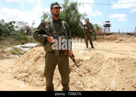 Un confine egiziano appare sullo sfondo come il palestinese Hamas delle forze di sicurezza pattugliano la zona di frontiera di Rafah tra Gaza ed Egitto su Aprl 14, 2016. Hamas chiede l Egitto per allentare il blocco da Gaza come chiamate in Egitto per Hamas di aumentare il numero di truppe e di controllo della frontiera tra Egitto e la striscia di Gaza .Hamas chiamato per l'Egitto per allentare le restrizioni sulla striscia di Gaza, un delegato detto, dopo da funzionari del gruppo islamista recato al Cairo per cercare di ricucire rapporti tesi. Alto funzionario Khalil al-Haya detto Hamas aveva implorato Egitto per consentire più il traffico attraverso il Rafa border cross Foto Stock