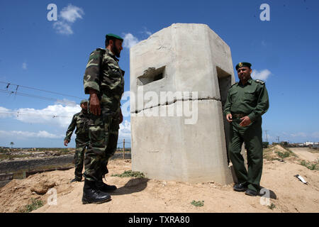 Un confine egiziano appare sullo sfondo, come un palestinese Tareq Abu Hashim (R), il comandante delle forze di sicurezza a Rafah. Guardando la zona di frontiera di Rafah tra Gaza ed Egitto su Aprel 14, 2016. Hamas chiede l Egitto per allentare il blocco da Gaza come chiamate in Egitto per Hamas di aumentare il numero di truppe e di controllo della frontiera tra Egitto e la striscia di Gaza .Hamas chiamato per l'Egitto per allentare le restrizioni sulla striscia di Gaza, un delegato detto, dopo da funzionari del gruppo islamista recato al Cairo per cercare di ricucire rapporti tesi. Alto funzionario Khalil al-Haya detto Hamas aveva implorato Egitto al al Foto Stock