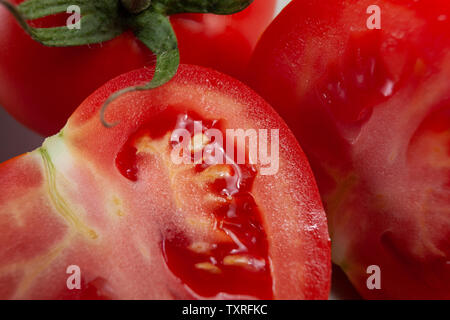 Fresco, pomodoro maturo, tagliate a metà, succosa, ancora con stelo verde, vicino fino Foto Stock