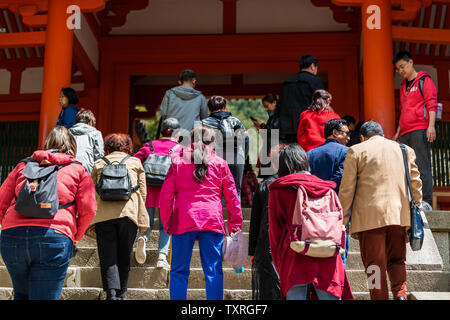Nara, Giappone - 14 Aprile 2019: persone folla indietro salendo le scale di Kasuga jinja gate con colore rosso Foto Stock