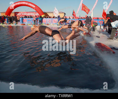 Sia il russo e il cinese nuotatori competere in invernale annuale concorso di nuoto durante il XIV Harbin Ice e Snow Festival, propagandato come il più grande del mondo di ghiaccio e neve festival, ad Harbin, la capitale della Cina settentrionale della provincia di Heilongjiang vicino a Russia, gennaio10, 2013. UPI/Stephen rasoio Foto Stock