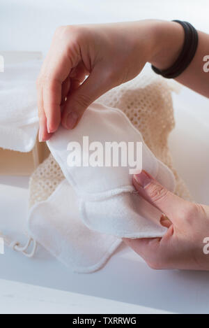 Piccoli asciugamani per il lavaggio del trucco. Asciugamani in microfibra per una facile pulizia. ragazza detiene il trucco quadranti. Foto Stock