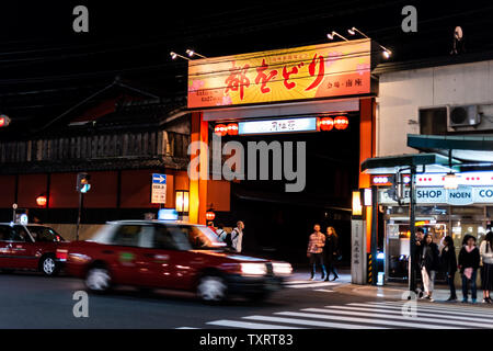 Kyoto, Giappone - 16 Aprile 2019: famosi shopping arcade Street nel quartiere di Gion durante la notte con ingresso a Hanamikoji Dori segno e taxi in movimento Foto Stock