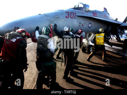 HST2003032008 - a bordo della USS Harry Truman, Mediterraneo orientale, 20 marzo (UPI)--ponte di volo equipaggio a bordo della portaerei USS Harry Truman spingere un F-18 Hornet nella posizione di riposo il giovedì 20 marzo, 2003 nel Mediterraneo orientale. MK/jg/John Gillis UPI Foto Stock