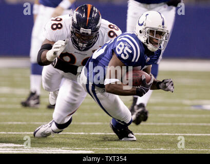Indianapolis Colts wide receiver Pierre Garcon (85) dives in avanti come egli è affrontato da Denver Broncos defensive lineman Ryan McBean (98) durante il primo trimestre a Lucas campo petrolifero di Indianapolis il 13 dicembre 2009. UPI /Mark Cowan Foto Stock