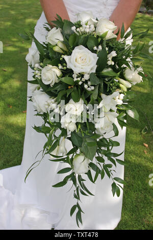 Sposa Azienda bouquet di fiori di rose e Lillies Foto Stock