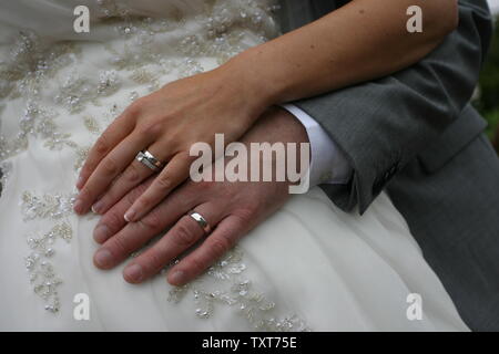 Sposa e lo sposo che collega le mani visualizzando gli anelli di nozze Foto Stock