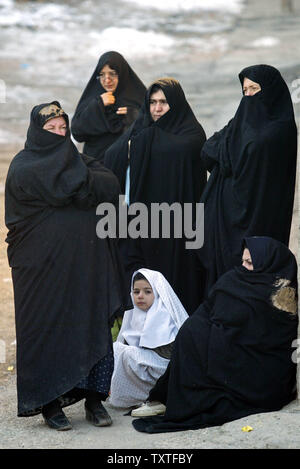 Sciita iraniano le donne musulmane di aspettare di essere coperto di fango durante una religione tradizionale cerimonia in Khorramabad, una città in provincia di Lorestan, 499 km (310 miglia) ad ovest di Tehran, Iran il 19 gennaio 2008. Ashura è il picco di dieci giorni di lutto durante il mese islamico di Muharram, il primo mese del calendario lunare, quando musulmani sciiti piangono la macellazione degli imam Hussein 1366 anni fa in che cosa ora è Karbala in Iraq meridionale. Persone in lutto mescolare acqua di rose con le piene in argilla di 12 metri quadrati. Essi sbattete leggermente le spalle con catene mentre le loro teste e le spalle sono state coperte Foto Stock