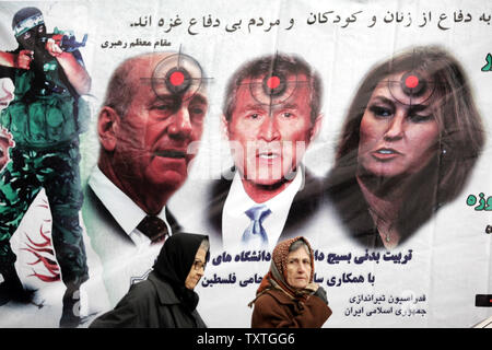 Due donne iraniane pass anti-Israele/USA banner con immagini di Israele il primo ministro Ehud Olmert (L), U.S. ex Presidente George W Bush (C) e Israele il Ministro degli Esteri Tzipi Livni al di fuori di Shiroudi complesso sportivo a Tehran, Iran il 5 febbraio 2009. Il fallimento dell'Iran a rilasciare i visti in tempo per un U.S. badminton squadra per giocare in un torneo a Teheran è stata denominata "sfortunati" da parte del governo degli STATI UNITI Dipartimento di Stato. Il 12-membro della delegazione era in rotta verso Teheran su invito del Iraniano Badminton russa di partecipare a un concorso internazionale da mercoledì a domenica. (UPI Foto Stock