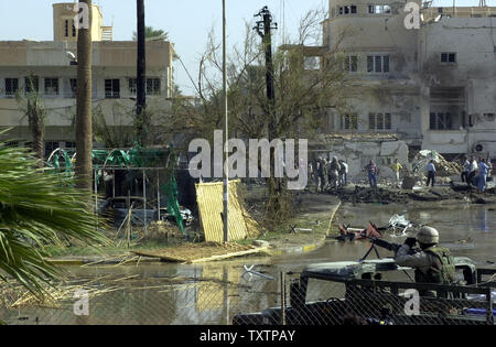 I soldati degli Stati Uniti e i soccorritori servey la situazione a seguito di un mortale attentato suicida presso la Croce Rossa sede a Baghdad, Iraq, il 27 ottobre 2003. L'attacco sulla croce rossa è venuto il primo giorno di vacanza musulmana del Ramadan ed era accoppiato con diversi altri attacchi su stazioni di polizia. (UPI/Mitch Prothero) Foto Stock