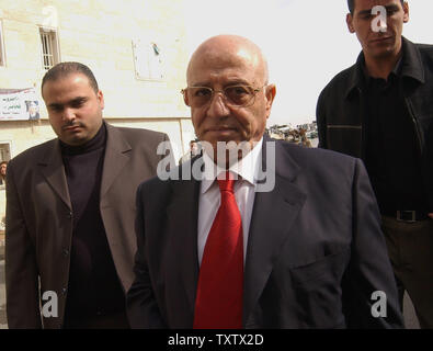 Il primo ministro palestinese Ahmed Qureia è accompagnato da guardie del corpo come egli arriva per il Consiglio legislativo palestinese incontro a ratificare la proposta per il suo gabinetto a Ramallah in Cisgiordania,Novembre 12, 2003. (UPI foto/Debbie Hill) Foto Stock