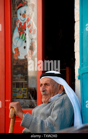 Un uomo palestinese si siede di fronte a un negozio turistico vicino alla chiesa della Natività, dove la tradizione dice che Gesù era nato in Betlemme, West Bank il 11 dicembre 2006. (UPI foto/Debbie Hill) Foto Stock