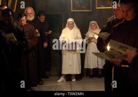 I sacerdoti e le Suore pregano nella grotta della Chiesa della Natività, dove la tradizione dice che Gesù era nato nella città biblica di Betlemme in Cisgiordania sul dicembre 20, 2006. (UPI foto/Debbie Hilll) Foto Stock