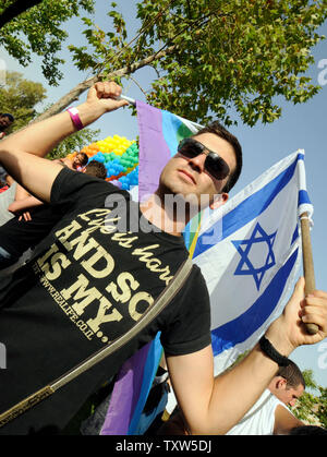 Un Israele porta una bandiera nazionale e una bandiera arcobaleno nel controverso annuale di Gay Pride Parade in Gerusalemme, 26 giugno 2008. Più di 3 mila persone hanno camminato in parata che era protetto da 2.000 della polizia e della polizia di frontiera. (UPI foto/Debbie Hill) Foto Stock