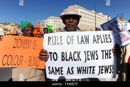 Etiope israeliani tenere le foto di parenti ancora in Etiopia a una dimostrazione al di fuori del Primo Ministro israeliano Benjamin Netanyahu dell'ufficio in Gerusalemme, 10 gennaio 2009. I manifestanti hanno chiesto al governo di fine della politica di discriminazione contro la concessione di immigrazione di ebrei etiopi. Ci sono alcuni 8.700 ebrei etiopi ancora in attesa di immigrare in Israele . UPI/Debbie Hill Foto Stock