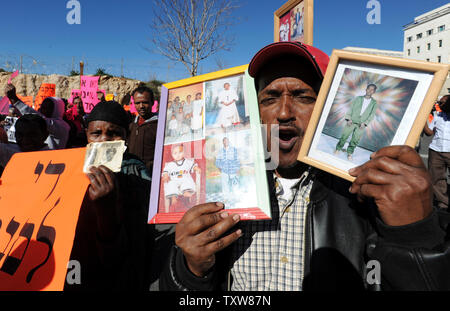 Etiope israeliani tenere le foto di parenti ancora in Etiopia a una dimostrazione al di fuori del Primo Ministro israeliano Benjamin Netanyahu dell'ufficio in Gerusalemme, 10 gennaio 2009. I manifestanti hanno chiesto al governo di fine della politica di discriminazione contro la concessione di immigrazione di ebrei etiopi. Ci sono alcuni 8.700 ebrei etiopi ancora in attesa di immigrare in Israele . UPI/Debbie Hill Foto Stock