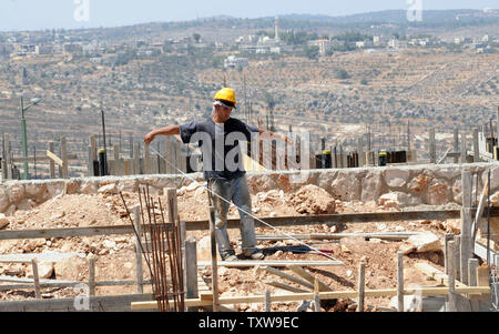 Un palestinese lavoratore edile costruisce una nuova casa israeliana in Har Gilo insediamento nella West Bank, 30 agosto 2010. Il presidente palestinese Mahmoud Abbas ha detto che Israele non può essere ritenuta responsabile per il fallimento della prossima di mediazione degli Stati Uniti i negoziati diretti se le attività di insediamento continua. UPI/Debbie Hill Foto Stock