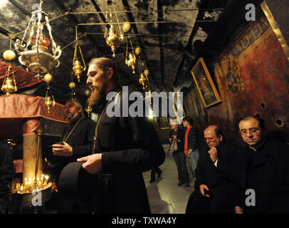 Chiesa ortodossa russa e sacerdote cattolico pregare nella grotta nella chiesa della Natività, dove la tradizione crede che Gesù Cristo è nato nella città biblica di Betlemme, West Bank, Dicembre 20, 2010. UPI/Debbie Hill Foto Stock