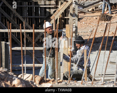 Costruzione palestinese lavoratori costruire il nuovo alloggiamento ebraica nell'insediamento israeliano Har Gilo nella West Bank, Dicembre 28, 2010. Più di 35.000 operai palestinesi sono impiegati la costruzione di nuove case negli insediamenti israeliani in Cisgiordania. UPI/Debbie Hill Foto Stock