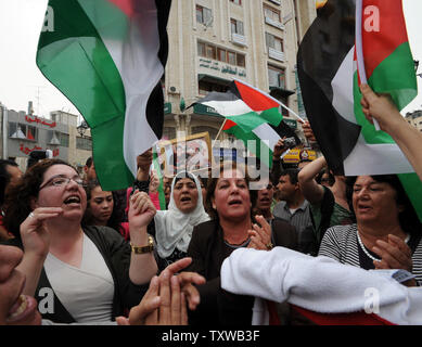 Palestinesi chant onda e bandiere nazionali durante un rally a Ramallah in Cisgiordania, per celebrare la firma dell'accordo di riconciliazione tra fazioni rivali, Hamas e Fatah, al Cairo, in Egitto, 4 maggio 2011. L'accordo di riconciliazione termina quattro anni di divisione ostile tra Hamas e Fatah e spiana la strada per i palestinesi elezioni generali che si terranno il prossimo anno. UPI/Debbie Hill Foto Stock