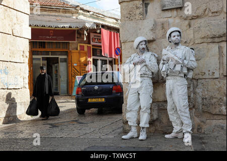 Artisti e di ex soldati israeliani, Yuda Braun, sinistra e Adam Miklef, destra, stand al di fuori del nuovo Gate nella Città Vecchia di Gerusalemme durante l'esecuzione di 'Il soldato bianco' , il 31 ottobre 2011. La pattuglia di artisti in piena lotta marcia lungo il 1967 Linea Verde che separa Israele dalla controllata Giordani a Gerusalemme Est, che è stata catturata da Israele nel 1967 guerra dei sei giorni. La performance è parte di una settimana d'arte lungo l'evento chiamato NOMANSLAND che risolve l'amarezza della linea di confine e la questione della riunificazione di Gerusalemme. UPI/Debbie Hill Foto Stock