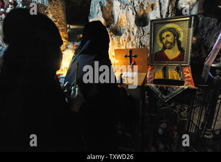 Suore ortodosse pregare da un dipinto di Gesù Cristo in un sito ritiene essere la prigione di Gesù sulla via Dolorosa, "la via della sofferenza" dove Gesù Cristo ha portato la croce per la crocifissione sul Venerdì Santo Ortodosso di Gerusalemme la città vecchia, 13 aprile 2012. UPI/Debbie Hill Foto Stock