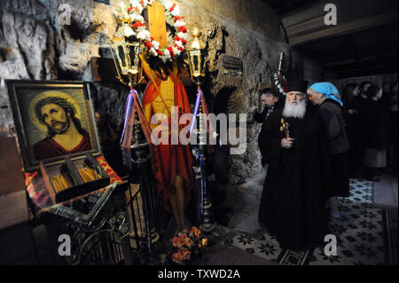 Un sacerdote ortodosso porta una croce in un sito ritiene essere la prigione di Gesù sulla via Dolorosa, "la via della sofferenza" dove Gesù Cristo ha portato la croce per la crocifissione sul Venerdì Santo Ortodosso di Gerusalemme la città vecchia, 13 aprile 2012. UPI/Debbie Hill Foto Stock