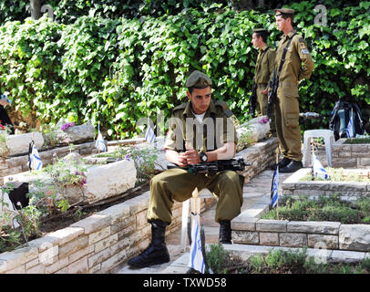 Un soldato israeliano si siede da le tombe dei caduti del Memorial Day nel Mt. Herzl cimitero militare in Gerusalemme, 25 aprile 2012. Il Memorial Day commemora caduti soldati israeliani dal 1948, prima della celebrazione del 64° anniversario della creazione dello Stato di Israele. UPI/Debbie Hill Foto Stock