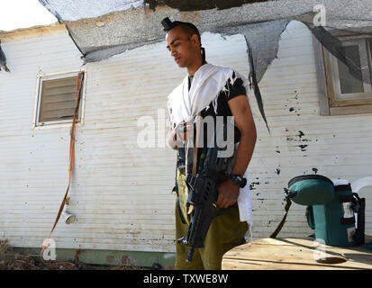 Un soldato israeliano detiene un'arma automatica mentre pregava nel traffico di insediamento ebraico avamposto Mitzpe Yair, vicino a Hebron in Cisgiordania, 19 ottobre 2012. UPI/Debbie Hill Foto Stock