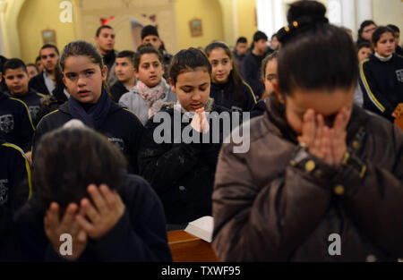 Cattolica palestinese studenti pregano durante un mercoledì delle ceneri la messa nella chiesa dell'Annunciazione di Beit Jala, West Bank, 13 febbraio 2013. Il Mercoledì delle Ceneri è il primo giorno della Quaresima nell ovest del calendario cristiano e cade 46 giorni prima di Pasqua. Le ceneri sono raccolte dalla combustione rami di palma del precedente la Domenica delle Palme e posto sulla fronte o le teste dei cristiani il Mercoledì delle Ceneri. Le ceneri sono un segno di lutto e di penitenza a Dio e segna i quaranta giorni di digiuno e di preghiera prima Domenica di Pasqua. UPI/Debbie Hill. Foto Stock