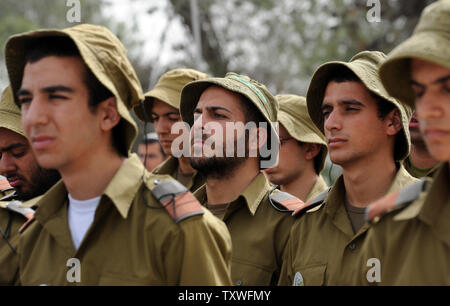 Israeliano soldati di combattimento stare in silenzio come un due minuti di sirena suona per onorare i sei milioni di ebrei che perirono sotto il regime nazista durante la Seconda Guerra Mondiale, durante un olocausto evento commemorativo sull olocausto dei martiri ed eroi' giorno del ricordo, nel martire foresta 'Scorrimento di fuoco", al di fuori di Gerusalemme, Israele, Aprile 8, 2013. UPI/Debbie Hill Foto Stock