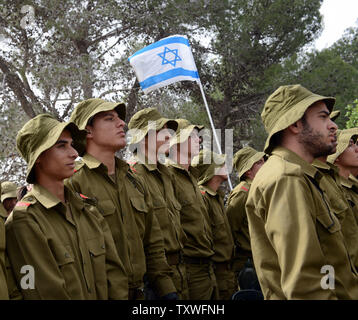 Israeliano soldati di combattimento stare in silenzio come un due minuti di sirena suona per onorare i sei milioni di ebrei che perirono sotto il regime nazista durante la Seconda Guerra Mondiale, durante un olocausto evento commemorativo sull olocausto dei martiri ed eroi' giorno del ricordo, nel martire foresta 'Scorrimento di fuoco", al di fuori di Gerusalemme, Israele, Aprile 8, 2013. UPI/Debbie Hill Foto Stock