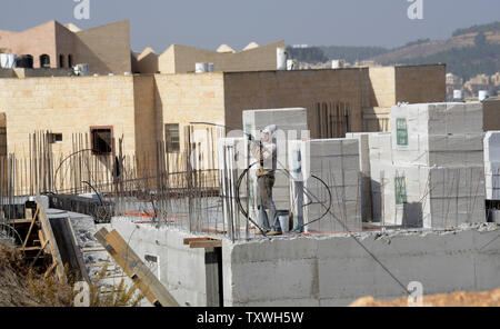 Un lavoratore palestinese costruisce nuovi ebraica unità alloggiamento nel contestato Ultra-Orthodox quartiere Ramat Shlomo a Gerusalemme est, 5 novembre 2013. Il Primo Ministro israeliano Benjamin Netanyahu ha annunciato che Israele potrà costruire 5.000 nuove unità abitative a Gerusalemme Est e nella West Bank, dopo il rilascio di 26 prigionieri palestinesi la scorsa settimana. Il Segretario di Stato americano John Kerry arriva in Israele questa sera per tenere colloqui con i dirigenti israeliani e palestinesi di domani. I palestinesi vedono gli insediamenti israeliani come un grosso ostacolo nei negoziati di pace. UPI/Debbie Hill Foto Stock