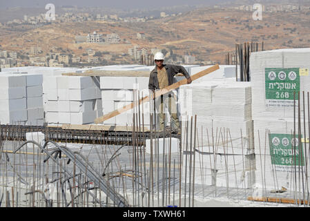 Un lavoratore palestinese costruisce nuovi ebraica unità alloggiamento nel contestato Ultra-Orthodox quartiere Ramat Shlomo a Gerusalemme est, 5 novembre 2013. Il Primo Ministro israeliano Benjamin Netanyahu ha annunciato che Israele potrà costruire 5.000 nuove unità abitative a Gerusalemme Est e nella West Bank, dopo il rilascio di 26 prigionieri palestinesi la scorsa settimana. Il Segretario di Stato americano John Kerry arriva in Israele questa sera per tenere colloqui con i dirigenti israeliani e palestinesi di domani. I palestinesi vedono gli insediamenti israeliani come un grosso ostacolo nei negoziati di pace. UPI/Debbie Hill Foto Stock