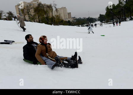 Palestinesi scorrere su una coperta di neve in collina Sachar Park nel centro di Gerusalemme, Israele, Dicembre 14, 2013. Una rara tempesta di neve ha coperto di Gerusalemme e il nord di Israele con una neve pesante, lasciando 35.000 famiglie senza alimentazione. UPI/Debbie Hill Foto Stock