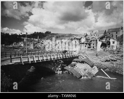 Didascalia originale recita: ribaltato un tedesco serbatoio consiste in un flusso poco profonde a fianco di un ponte ricostruito in devastate dalla guerra Houffalize, Belgio. Il lavoro di ricostruzione della battaglia-regioni strappato delle Ardenne, il Belgio ha iniziato a. Civili belga sono la rimozione dei detriti di edifici distrutti durante lo sfortunato tedesco contro-offensiva lanciata il 16 dicembre 1944, e la riparazione di strutture danneggiate e le strade. Quando i nazisti hanno sfondato le nella zona di rigonfiamento, molte sezioni sono state lasciate in rovina, alcuni di esso causato da Allied potenza aerea operante a sostegno delle forze di terra per forzare il maresciallo Gerd von Rundst Foto Stock