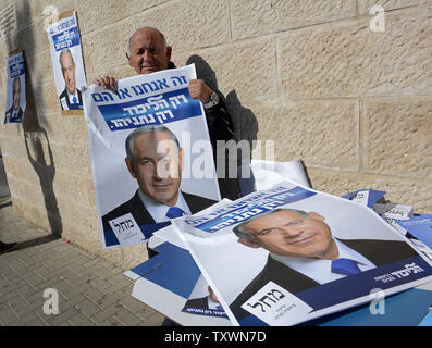 Un israeliano mantiene la campagna di manifesti del Primo Ministro israeliano Benjamin Netanyahu al di fuori di un seggio nel centro di Gerusalemme, Israele, in Israele la elezione generale, 17 marzo 2015. Foto di Debbie Hill/UPI Foto Stock