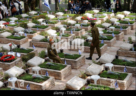 Un soldato israeliano si siede da le tombe dei caduti del Memorial Day nel Mt. Herzl Cimitero militare di Gerusalemme, Israele, 22 aprile 2015. Migliaia di Israeliani hanno visitato i cimiteri in tutto il paese per piangere la 23,320 caduti in Israele le battaglie fin dal 1948. Foto di Debbie Hill/UPI Foto Stock