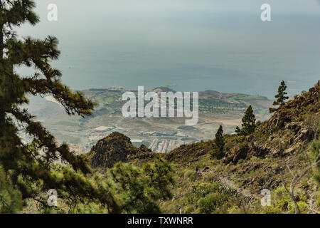 Vista aerea della parte ovest della costa al giorno di sole. Cielo blu e nuvole. Tracciamento rocciose su strada asciutta in zona di montagna. Tenerife, Isole Canarie. Foto Stock